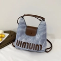 Dettaglio della borsa tote in denim azzurro con manici in pelle marrone e ricamo 3D - Blu Denim