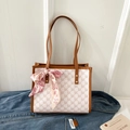 Detail of monogram tote bag with silk scarf accessory on denim jacket setting - Yellow Brown