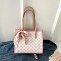 Detailed view of pink monogram tote bag with silk scarf on denim jacket backdrop - Pink