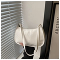 Close-up of white glossy patent leather surface with metallic zipper on the hobo bag - White
