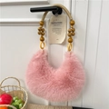 Pink faux fur half-moon handbag with beaded wooden handle hanging on a door handle - Pink