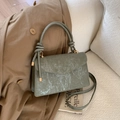 Detail of grey-green textured envelope bag with knotted handle and golden hardware - Green
