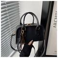 Detail der schwarzen Boston-Tasche mit goldenen Reißverschlüssen und Tennisschläger-Anhänger - Mit Anhänger / Schwarz