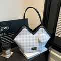 Blue gingham tote bag with black leather trim and detachable coin purse on white books - Blue