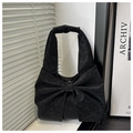 Dettaglio di una borsa nera con un grande fiocco e finitura opaca in similpelle - Senza Ciondolo / Nero