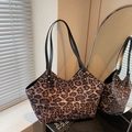 Detailaufnahme der Shopper-Tasche mit Leopardenmuster, schwarzen Lederriemen und Drehverschluss - Kaffeebraun