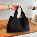 Minimalistische schwarze matte große Tragetasche auf einer Holzoberfläche für den Alltag - Schwarz