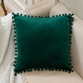 Dark green velvet pillow cover with matching pom-pom edges on a sofa background - Dark Green