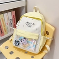 Detail view of a yellow school backpack featuring a clear front pocket and cute animal print - Yellow