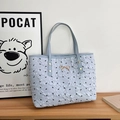 Detailed view of lavender puff fabric tote with black bows and gold metal accent - Blue