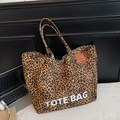 Détail de la texture en toile imprimé léopard et de l'inscription blanche TOTE BAG - Marron