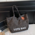 Détail du grand sac cabas en toile léopard avec étiquette en cuir orange sur le côté - Marron