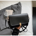 Detail einer minimalistischen schwarzen Ledertasche mit eleganter goldener Metallschnalle - Schwarz