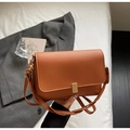 Detail der karamellbraunen PU-Ledertasche mit goldener Metallschnalle und Textur - Braun