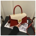 Detail of red and beige patchwork handbag featuring woven texture and a gold M-buckle - Red