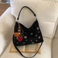 Detalle del bolso de ante negro con ojales metálicos plateados y colgante decorativo - Sin Colgante / Negro