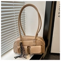 Detail view of apricot soft leather handbag with dual front flap pockets and braided charm - With Pendant / Khaki