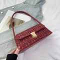 Macro shot of wine red tweed shoulder bag with gold metallic threads and leather handle - Red
