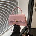 Elegant pale pink trapezoid handbag with gold twist lock and stylish top handle - Pink