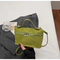 Close-up of avocado green suede box bag featuring unique heart-shaped silver zippers - Green