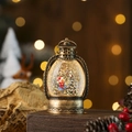 Close-up of vintage bronze Christmas lantern with sparkling snow and interior festive scene - Bronze Child with Tree