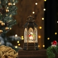 Primer plano de farol navideño de bronce con muñeco de nieve y efecto de nieve brillante - Muñeco de nieve no giratorio