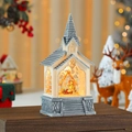 Vista macro de la bola de nieve con diseño de iglesia, belén y base de piedra vintage - Estilo Escena del Nacimiento