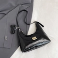 Bolso hobo negro brillante con hebilla dorada y correas ajustables sobre tela - Negro