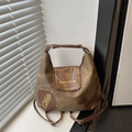 Brown canvas and leather patchwork tote bag with artistic letter print shown in a bright room - Brown