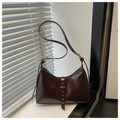 Dettaglio borsa marrone scuro in ecopelle con cinturino con rivetti ed effetti di luce - Marrone