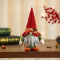 Kerstkabouter knuffel met rode gebreide muts en dennenappel op warme gezellige achtergrond - Jongensstijl met Lange Baard / Rode Muts