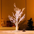 Close-up of 65cm snow-flocked LED Christmas tree with white base for tabletop decor - Colorful