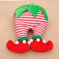 Detail of Christmas elf legs with red and white stripes, green trim, and small golden bells - Elf Stripe Style