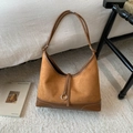 Detail van vintage bruine hobo tas met contraststiksels en zilveren metalen ringaccenten - Bruin
