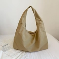 Detail view of khaki nylon tote bag with wide strap and zipper on white fabric - Khaki