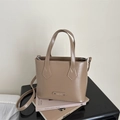 Detailansicht der khakifarbenen Beuteltasche mit Fashion-Plakette und Ziernähten - Khaki