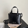 Detail der schwarzen Leder-Beuteltasche mit silberner Fashion-Metallplatte und Henkel - Schwarz