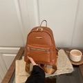 Brauner Web-Rucksack mit Gold-Reißverschluss und Vordertasche in gemütlichem Ambiente - Braun