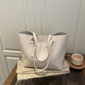 Classic white faux leather tote bag with dual straps in a cozy lifestyle setting - White