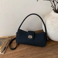Bolso bandolera vintage de tela negra con hebilla dorada sobre una mesa de madera rústica - Negro