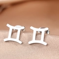 Polished silver stainless steel Gemini zodiac sign stud earrings on silk background - Silver Gemini (F1206-Gemini)