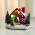 Casa navideña de resina iluminada con Papá Noel y luces LED sobre base de nieve brillante - Techo Rojo (Luminoso)