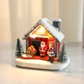 Casa navideña de resina luminosa con cabaña roja, Papá Noel y cálidas luces LED - Techo Blanco (Luminoso)