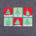 Détail d'un set de table de Noël avec des motifs de sapins colorés sur fond rouge et vert - Sapin de Noël