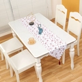 White Christmas table runner with red star prints and a decorative tassel at the end - Red Star Style