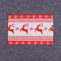 Détail d'un set de table de Noël avec motifs de rennes et de flocons rouges et blancs - Renne de Noël bleu