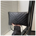 Close-up of black envelope bag with chevron quilting and silver metal rivet studs - Black