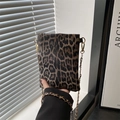 Detail der Mini-Umhängetasche mit Leopardenmuster und goldener Kette von Model gehalten - Braun