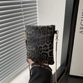 Detail der Handtasche mit Leopardenmuster, goldener Kette und strukturierter Lederoptik - Schwarz