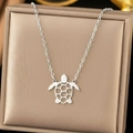 Elegant stainless steel necklace with hollow turtle pendant on champagne silk background - C7010